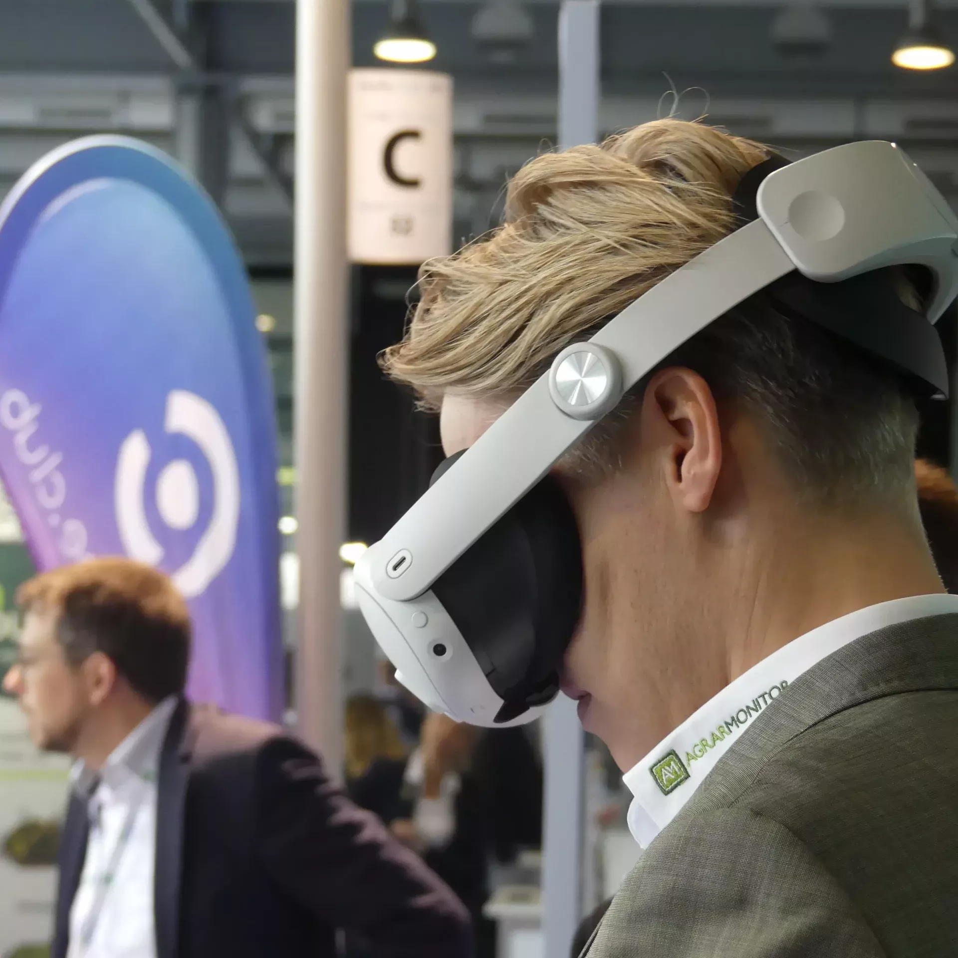 Torben Calenberg von Agrargmonitor im Profil mit einer weißen VR Brille der um sich guckt.