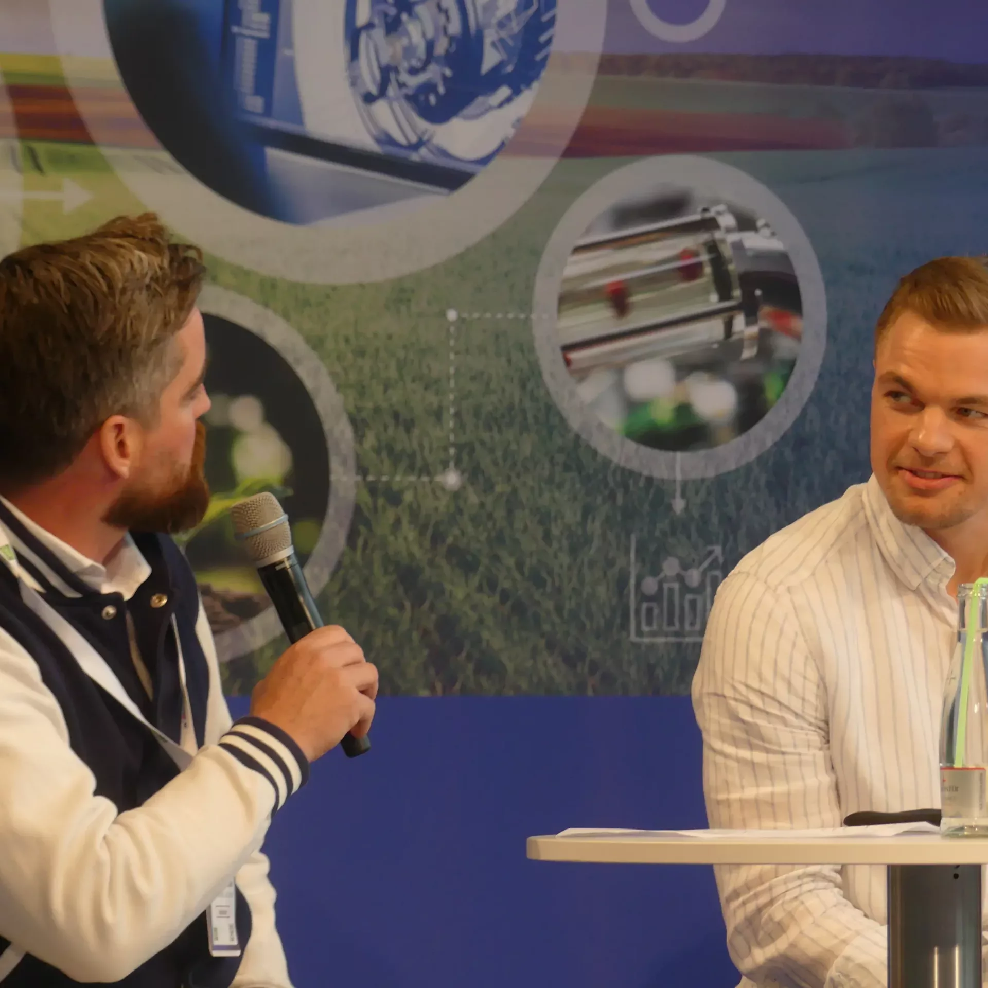 Nahaufnahme Chrisitan Schweizer interviewt einen Mann, der ihm gegenüber sitzt auf der Expert stage.